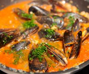 Sauteed mussels with a tomato and garlic broth.